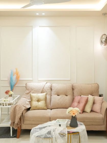 This living room is a study in minimalist luxury. The soft beige sofa, delicate decor, and white walls with elegant moulding create a calm and sophisticated environment.