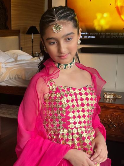 A final portrait of the young client with her stylish braided pony, a great inspiration for kids' festive hairstyling.