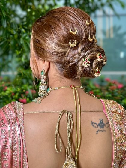 A view of the elegant bridal bun, adorned with traditional Maharashtrian hair accessories, completing this stunning look.
