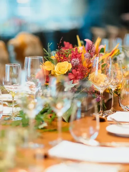 An elegant table setting for a corporate fine dining event. The warm colours and sophisticated floral arrangements create a professional yet welcoming atmosphere for networking and celebration.