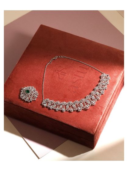 The Diamond Willow necklace shown with its pendant detached. This highlights the two separate pieces, the simpler necklace and the ornate brooch-like pendant, which can be worn independently.