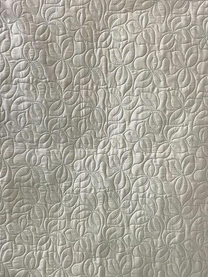 The back of the gradient quilt, showing a simple leaf-like quilting pattern.