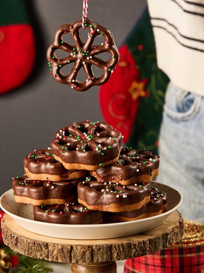 Our Chris's Rose Cookies are a nostalgic Christmas treat. These delicate, flower-shaped cookies are dipped in chocolate and decorated with festive sprinkles, perfect for hanging on your tree or enjoying with hot chocolate.