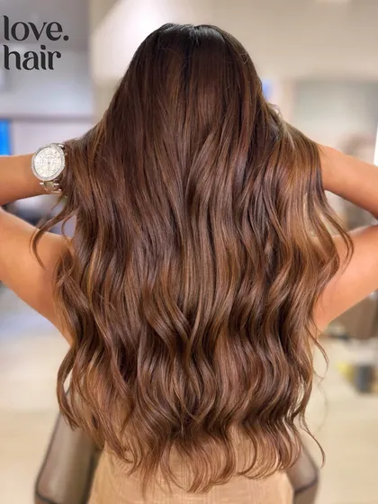 The full view of this delicious Nutella brown hair, styled in glossy waves.