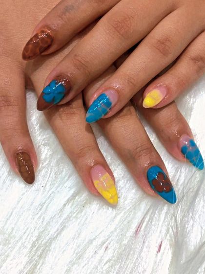 A still shot of the abstract, multi-colored nail art.