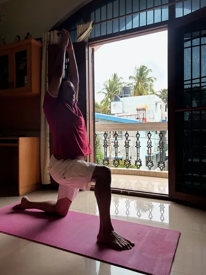 Our personal training extends to the comfort of your home. This is Pratap during his at-home session, working on Anjaneyasana (Low Lunge) to improve flexibility and strength as part of his customized fitness plan.