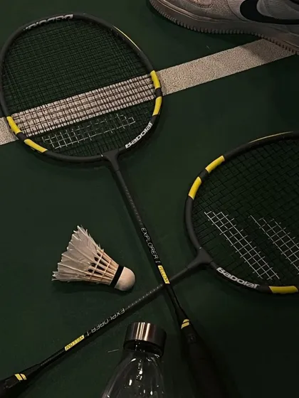 The tools of our trade. A couple of rackets, a shuttle, and a water bottle. Everything you need for a great session.