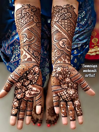 For this beautiful bride, I created a swirling, intricate design that flows from the palm all the way up the forearm. We also included the couple's names, 'Chandu' and 'Madhu', right in the center of the palms.