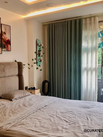 A full view of the teenager's bedroom, which opens onto a balcony with lush green views. The room is designed to be a calm and simple retreat.