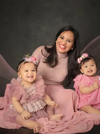 Double the giggles and double the love with these beautiful twin sisters. This portrait with their mommy shows the pure happiness of their family, captured with a flowing fabric backdrop for an artistic touch.