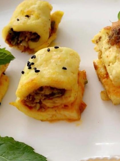 Mini egg rolls filled with a savory stuffing. These bite-sized rolls are a delicious and easy-to-eat snack, garnished with fresh mint.