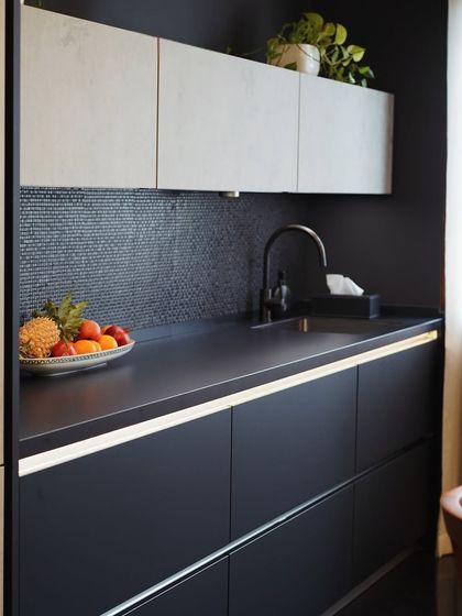 This view highlights the secondary prep area in the Mibu Residence kitchen. The combination of a dark mosaic backsplash and under-cabinet lighting creates a functional and atmospheric workspace.