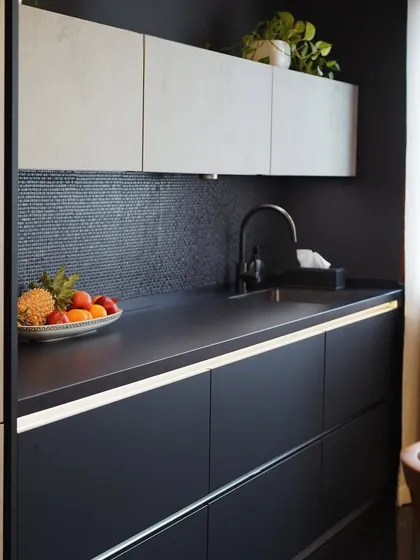 This view highlights the secondary prep area in the Mibu Residence kitchen. The combination of a dark mosaic backsplash and under-cabinet lighting creates a functional and atmospheric workspace.