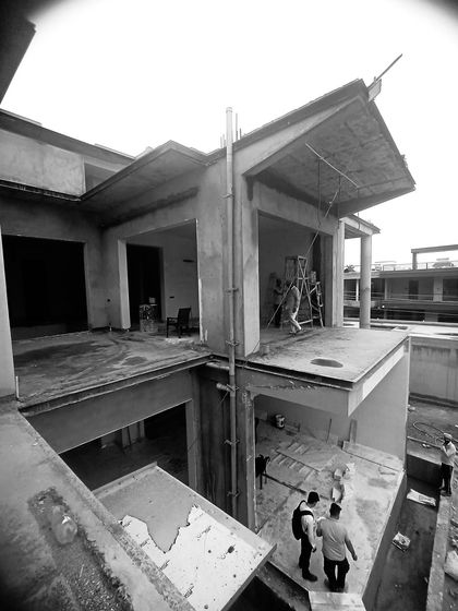 An on-site shot of a 15,000 sq. ft. architectural project taking shape. This view from above shows the complex interplay of levels and volumes, highlighting the strong geometry and clean lines that define the home's structure even in its early stages.