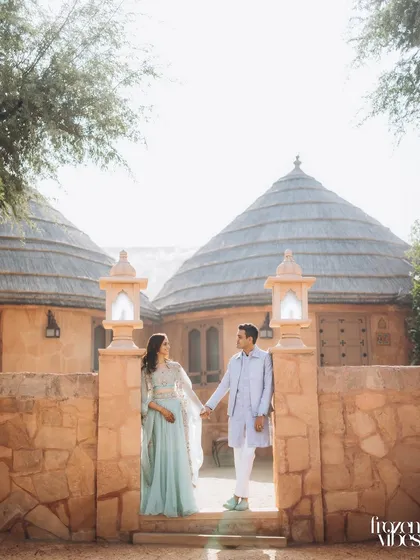 Saloni and Kanav at the entrance of the Khimsar Dunes Village. The unique, rustic architecture of the huts provides a wonderful backdrop for a desert-themed shoot.