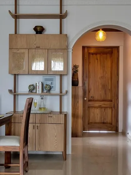 This view from the dining area looks down a hallway with a beautiful arched doorway. The warm wood tones of the furniture and doors create a cohesive and inviting flow through the home.