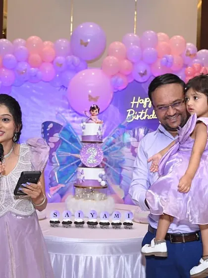 The mother gives a speech while the family stands by the stunning butterfly cake.