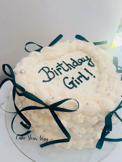 A dramatic and glamorous vintage-style cake with dark green ribbons.