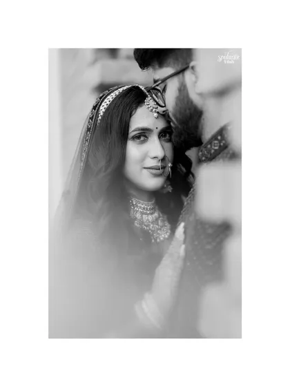 An intimate black and white portrait of the couple. The soft focus and close framing create a dreamy, romantic mood, drawing attention to the bride's gentle gaze.