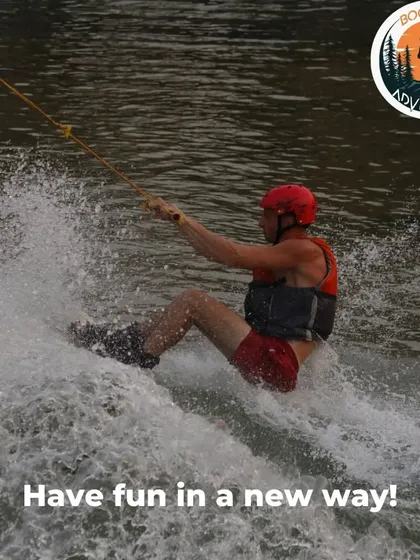 Having fun in a new way. This rider is enjoying the speed and excitement of being pulled across the lake. It's a unique water sport that combines elements of surfing and water skiing.