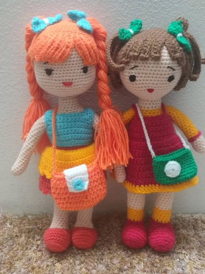 Two beauties in one frame. One has orange hair and the other has brown hair. Both are wearing colorful outfits.