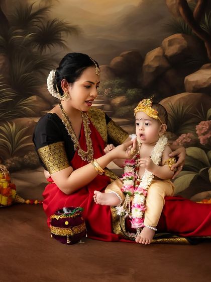 A mother gently interacts with her baby, who is seated and dressed as Krishna, creating a quiet and intimate portrait.