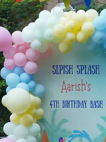 The main backdrop for the pool party, featuring a custom "Splish Splash" design and a colorful pastel balloon garland.