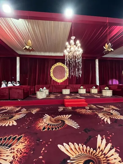 A regal lounge area with deep red velvet sofas, set on a custom carpet with a striking phoenix-wing pattern.
