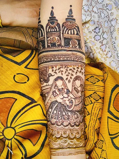 A traditional design featuring a bride and groom portrait on the arm, with architectural dome elements above them. This style is perfect for telling a story through henna.