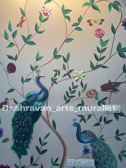 A relief mural featuring the classic peacock theme. The bodies of the peacocks and the tree branches are sculpted in 3D, adding a tactile dimension to the traditional painted design.