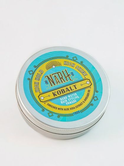 A simple, clean shot of a tin of hair styling pomade. The high-angle view clearly shows the branding and lid design, perfect for a catalogue.