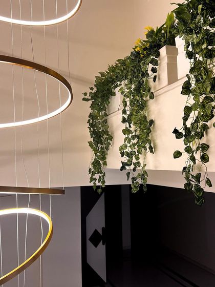Faux hanging ivy cascades down from a ledge, softening the architecture and adding a touch of natural beauty. Hanging plants are an excellent way to add greenery to vertical spaces.