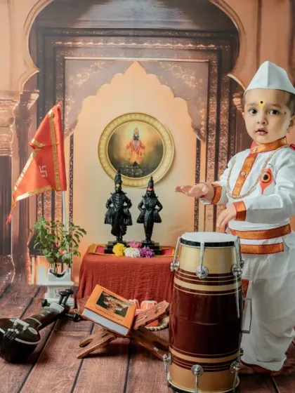 A wider shot of the toddler Varkari with the dhol and tanpura, showing the full scale of the detailed studio setup.