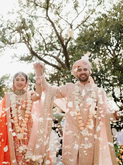 A shower of petals for the happy couple. This photo captures the pure joy of the moment, surrounded by the beautiful ombré floral decor of their garden wedding.
