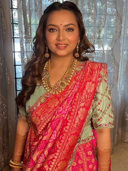 A full view of this beautiful look for a pre-wedding event. The makeup is fresh and radiant, complementing her pastel and pink outfit.