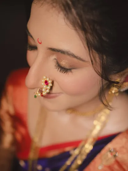 A detailed shot focusing on the iconic Maharashtrian nath and the soft, shimmering eye makeup. It’s these small details that complete the traditional bridal look.