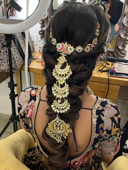 A close up of this trendy messy braid with stunning accessories. This is a great option for a Mehendi or Sangeet event, combining traditional elements with a modern twist.