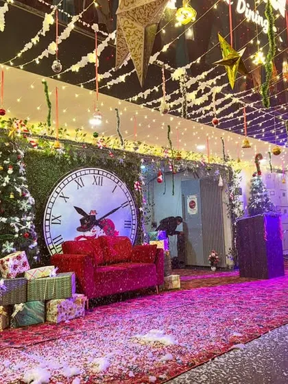The full view of the cafe's outdoor area, decorated with string lights, garlands, and a festive photo corner.