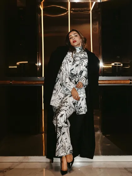 A full-length shot of Malaika Arora leaning against the elevator wall, creating a strong and stylish composition.