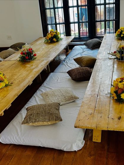 For traditional functions, we can arrange low seating with rustic wooden tables and comfortable floor cushions for guests.