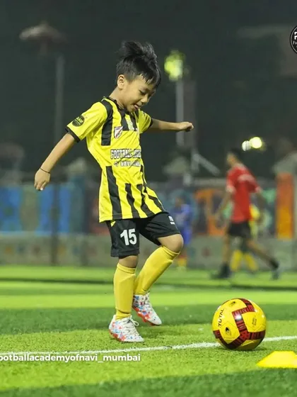 A young player shows great technique and focus while practicing his ball control.