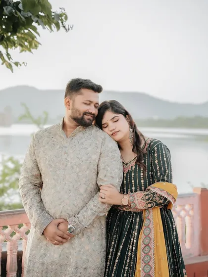 A tender and emotional portrait of the couple, showcasing the soft, warm light of a lakeside sunset.