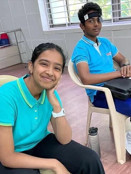 A moment of rest between practice rounds. Competitions can be long, and learning to manage energy and focus is part of the training.
