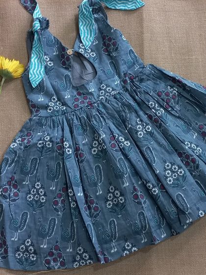 The back view of our 'pakshi' print frock, showing the keyhole detail and the pretty contrasting fabric on the ties. Every little detail is thoughtfully designed.