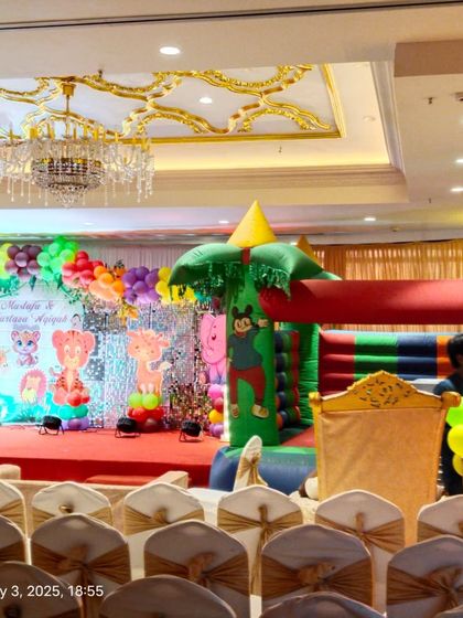 A wide shot of the jungle-themed event, showing the stage decor and an inflatable bouncy castle we arranged for kids' entertainment.