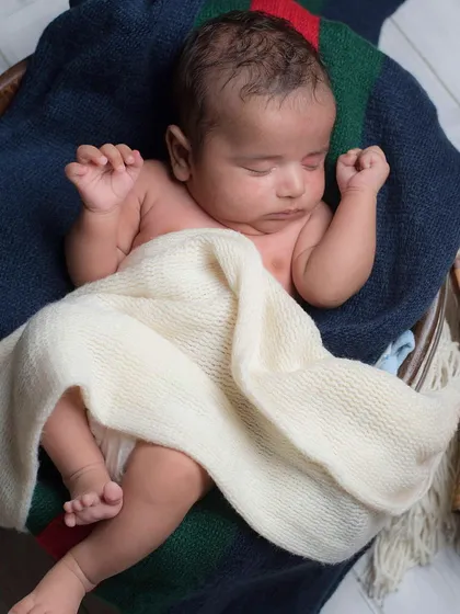 Our studio sessions are designed around your baby's comfort and your personal style. In this photo, we created a cozy, literary-themed setup by placing the sleeping baby in a comfortable bowl prop alongside a stack of books, showing how we can incorporate your hobbies and interests.