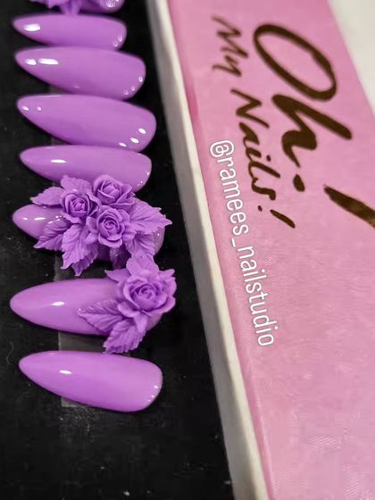 Custom press-on nails are a great option for reusable art. This set features a lovely lilac color with two accent nails covered in a stunning, intricate 3D rose bouquet.