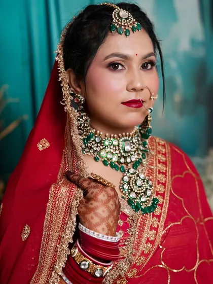 A classic red bridal look with contrasting green jewelry. Our student has perfected the art of the traditional bride with a modern touch.
