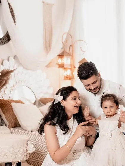A beautiful family portrait filled with laughter and joy. The parents are fully engaged with their daughter, creating a natural and heartwarming scene.