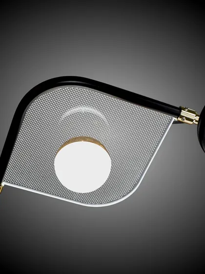 A close-up detail of the modern six-arm chandelier, showing the textured glass panel and the simple globe light. The combination of black and gold finishes is very sophisticated.